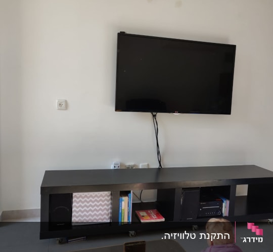 טלוויזיה תלויה על הקיר עם כבלים חשופים